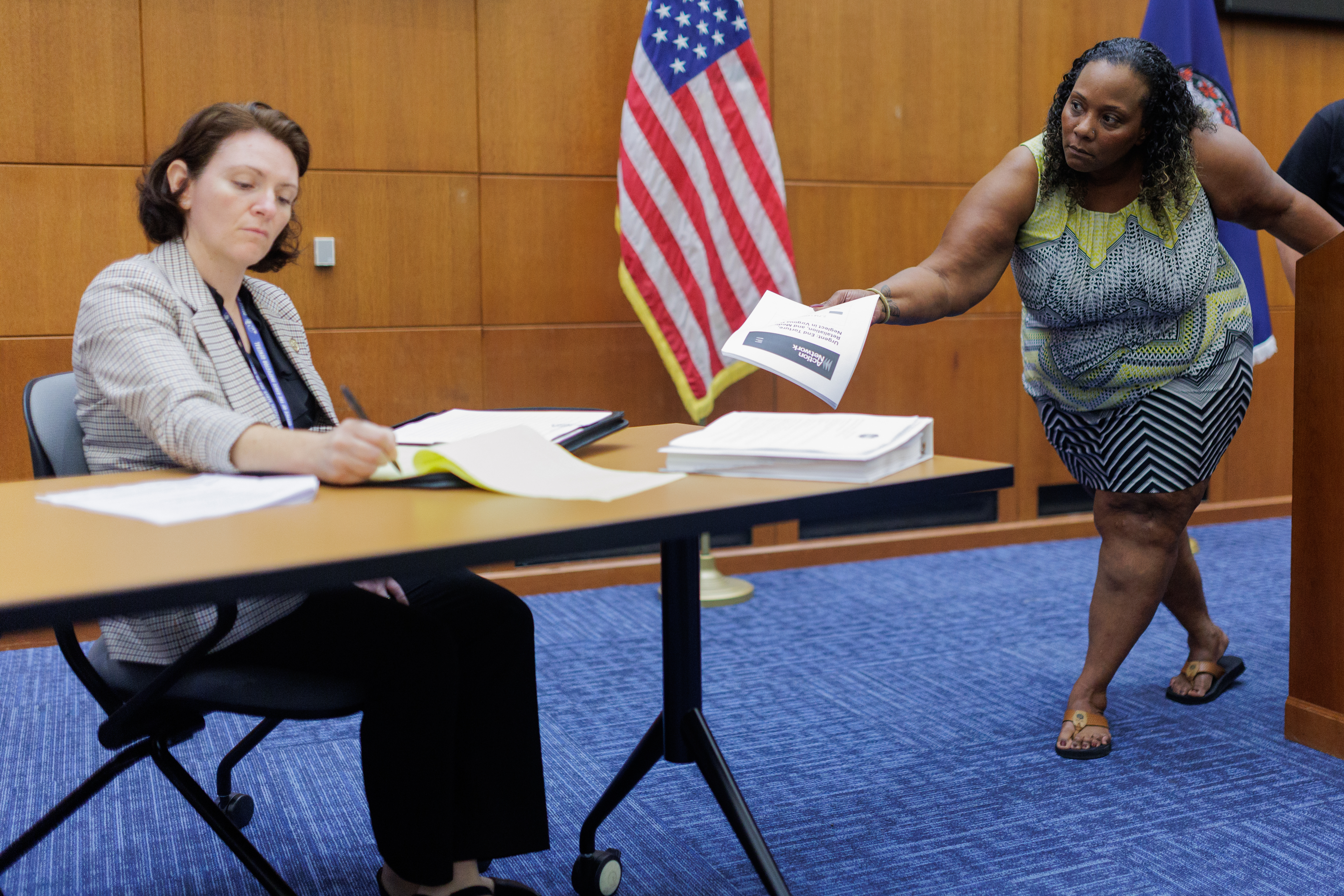 Melinda Evans, right, tries to make eye contact with OSIG Corrections Ombudsman Andrea Sapone as she hands her a document during a public stakeholder meeting on Thursday, October 2, 2025, at the Patrick Henry Building in Richmond.