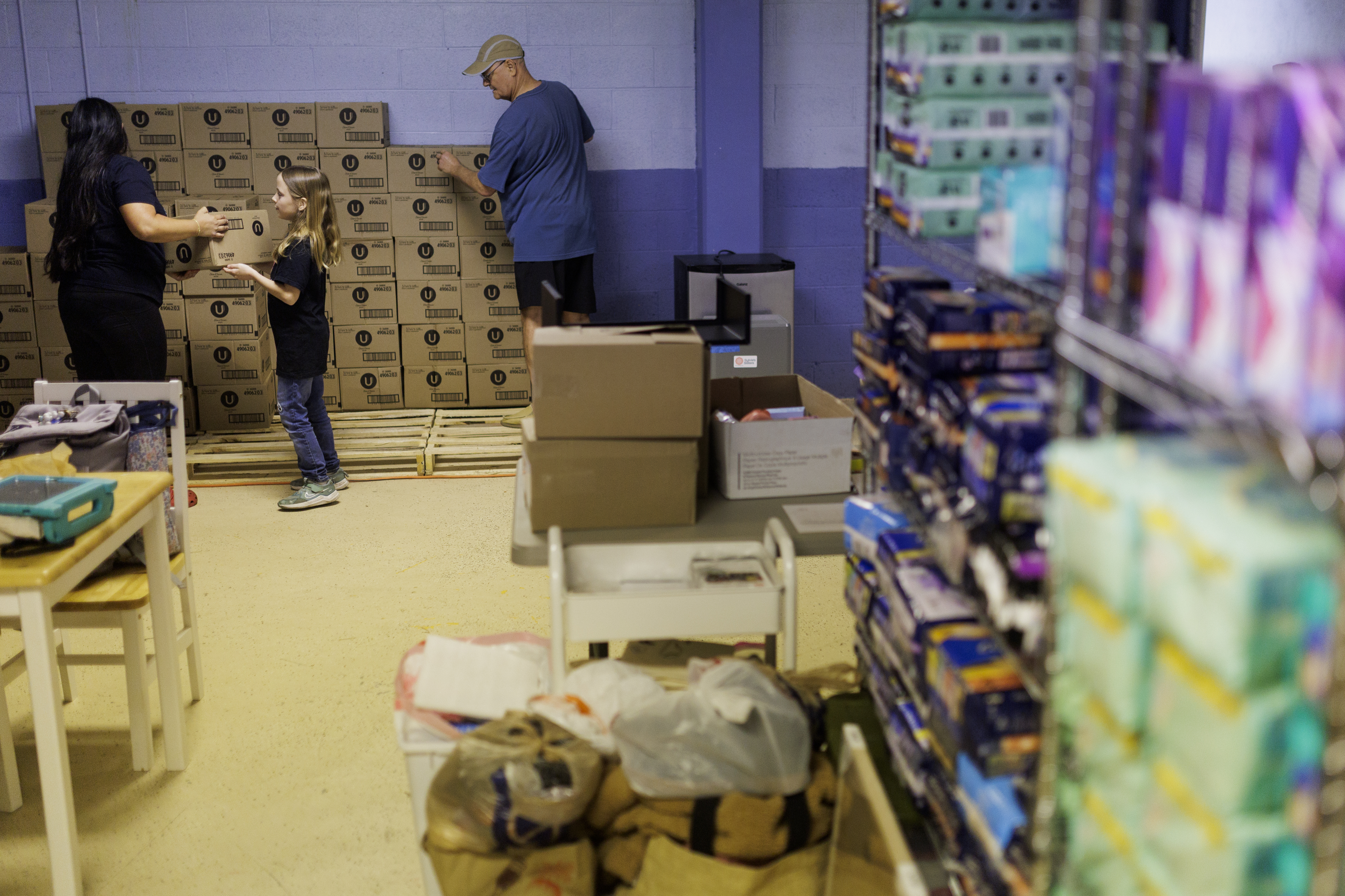 Mimi Isaac and Caroline Treanor, 11, work with Keith Mitchell to unload recently donated menstrual health products on Thursday, May 28, 2026 in Richmond, Virginia.